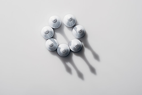 top view of chess figures in circle with shadows on white background