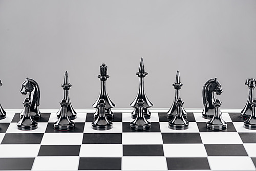 black and white chessboard with black figures isolated on grey