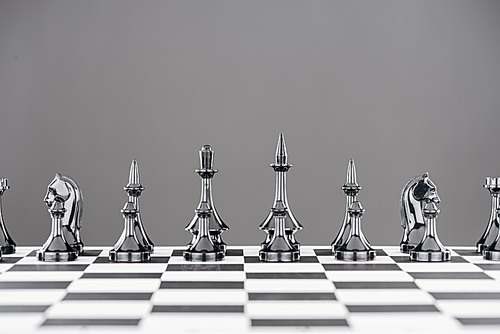 black and white chessboard with black chess figures isolated on grey