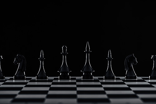 chessboard with black chess figures isolated on black