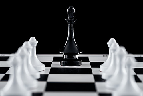 selective focus of chessboard with black queen figure among white pawns isolated on black