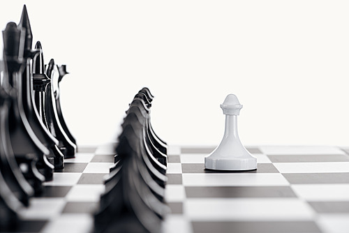 selective focus of chessboard with black chess figures and white pawn in front isolated on white