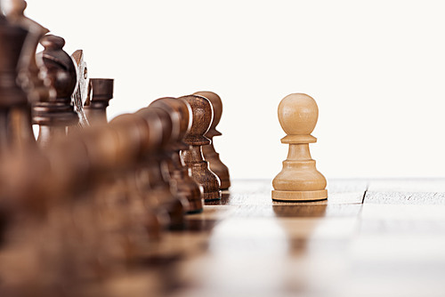 selective focus of wooden chessboard with chess figures and pawn in front isolated on white