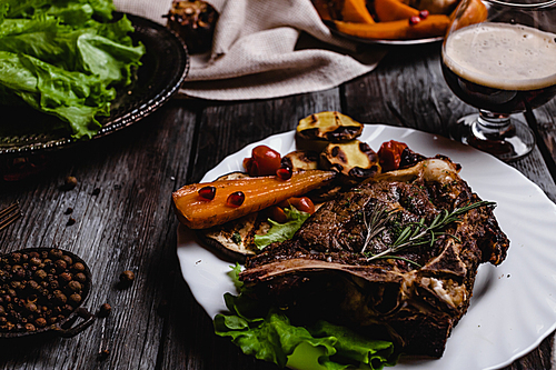 close-up shot of delicious grilled steak with vegetables on gray wooden table