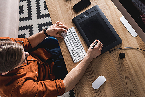 high angle view of young designer working with drawing tablet at workplace