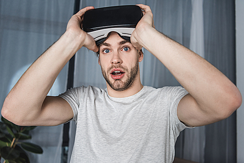 shocked young man in virtual reality headset