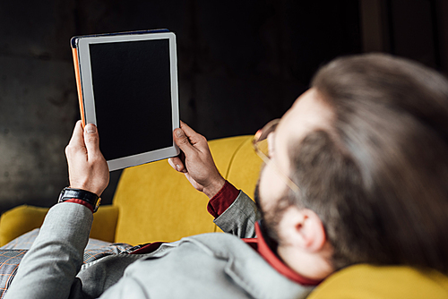 back view of man using digital tablet with blank screen