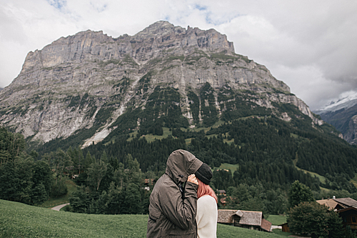 side view of young couple in love hugging and beautiful mountain landscape behind, Bern, Switzerland