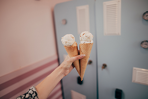 close-up partial view of girl holding delicious ice cream in waffle cones