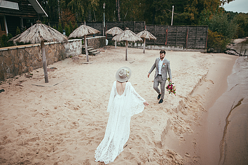beautiful happy bride and groom in bohemian style on beach