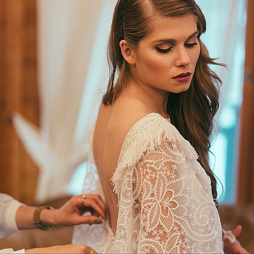 attractive stylish bride wearing white bohemian wedding dress
