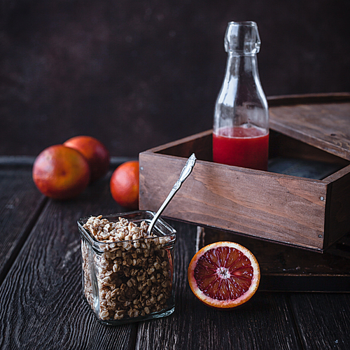 close up view of granola and fresh pomegranate fruit on wooden tabletop