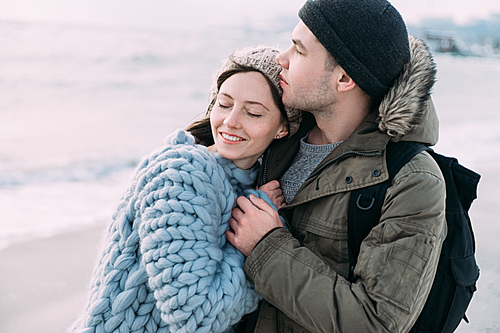 smiling tender couple hugging on winter seashore