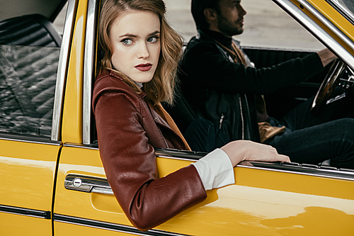 attractive stylish girl looking away while boyfriend driving car