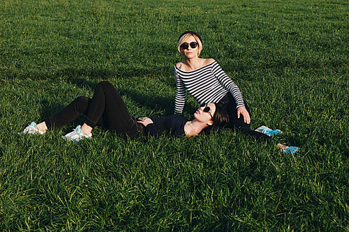 attractive young women relaxing on green grass in park