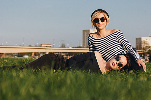 beautiful young women relaxing on green grass in park