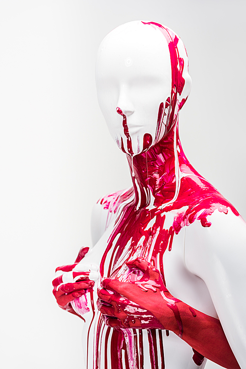 cropped image of girl in red paint touching mannequin breasts isolated on white