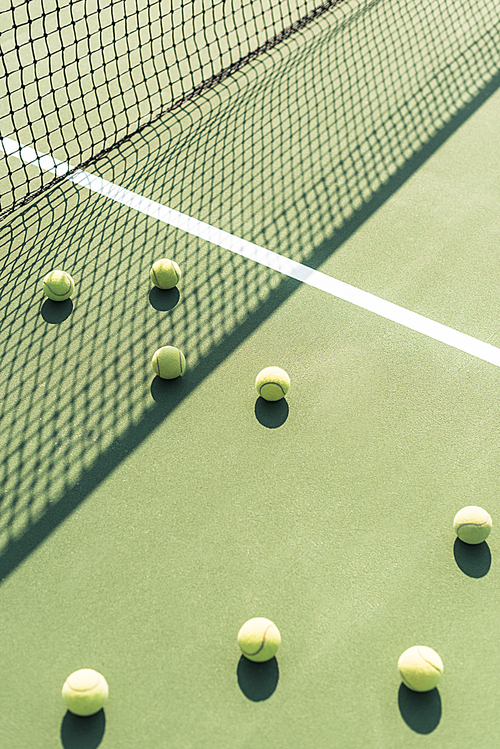 close up view of tennis balls and net on tennis court