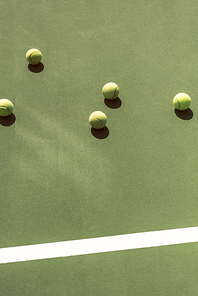 close up view of tennis balls on green tennis court
