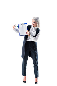 smiling businesswoman in formal wear pointing at empty notepad isolated on white