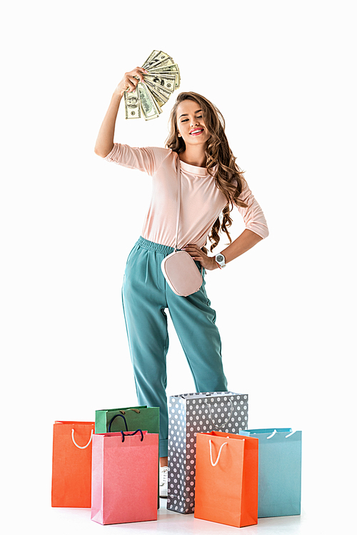 happy girl holding dollars and shopping bags, isolated on white