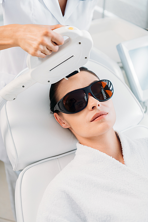 유토이미지 woman in protective eyeglasses getting laser hair removal made