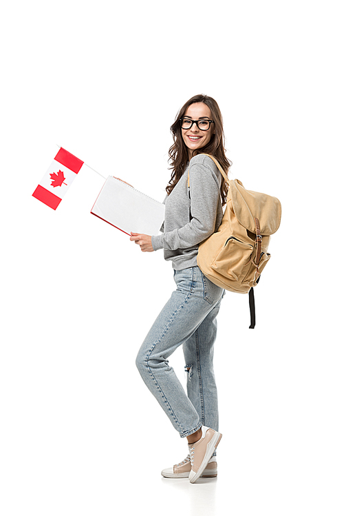 female student with backpack holding canadian flag and notebook isolated on white