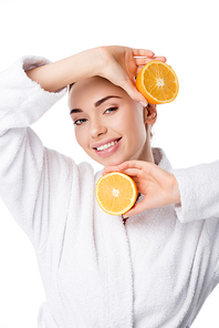 beautiful smiling woman in white bathrobe holding oranges isolated on white