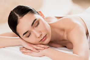 beautiful asian woman resting with closed eyes at spa