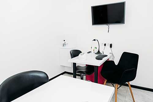 empty manicure salon with tables and chairs