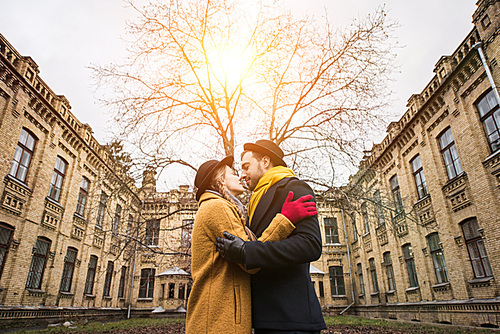 cheerful attractive young couple hugging infront of building