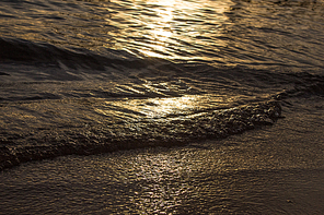 beautiful sea waves and sandy beach at sunset