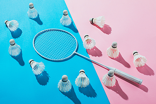 shuttlecocks around badminton racket on blue and pink papers