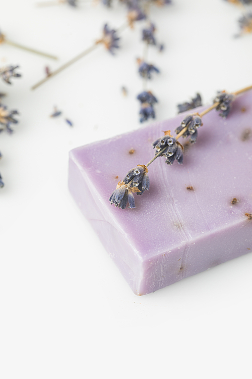 close-up shot of natural handcrafted soap with beautiful lavender flowers on white surface