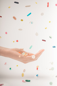 Cropped image of female hand catching colored falling pills