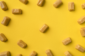 Top view of Scattered iris milk candies isolated on yellow