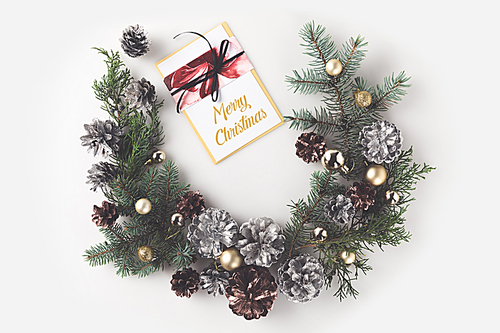 christmas wreath with balls and pine cones, with greeting card, isolated on white