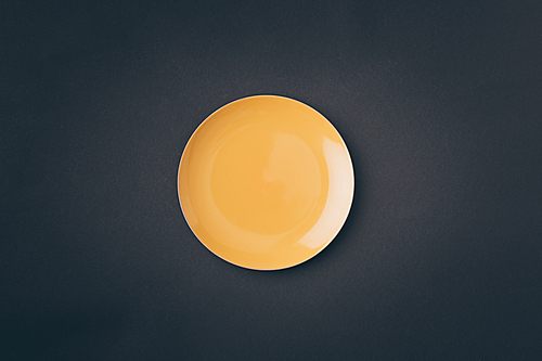 top view of yellow plate on gray table
