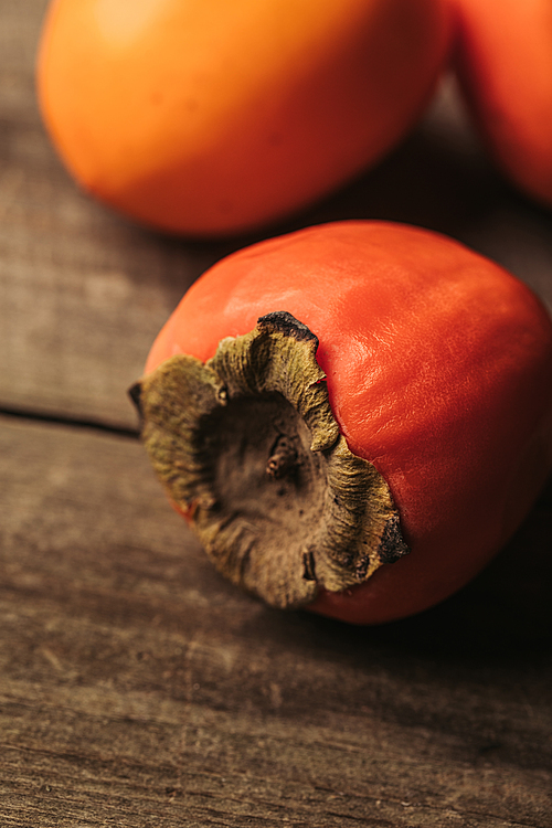 close up view of ripe persimmons on wooden table