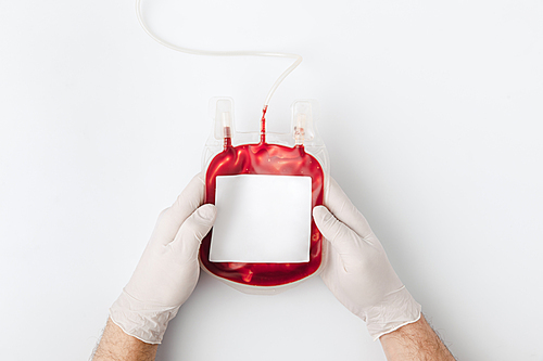 top view of hands in gloves holding blood for transfusion isolated on white