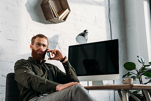 handsome businessman talking by smartphone and looking away