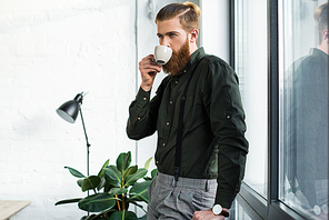 handsome businessman drinking coffee in office