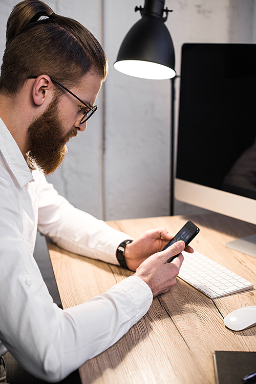 handsome businessman using smartphone in office