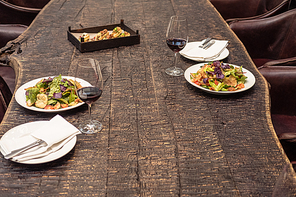 delicious salad with wine on rustic wooden table for romantic dinner