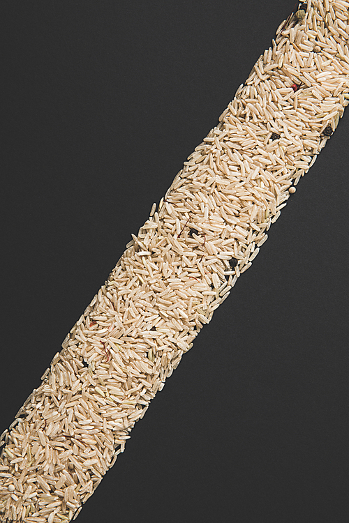 diagonal stripe of raw rice isolated on black