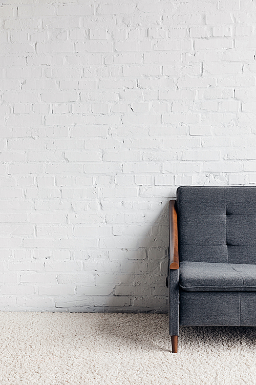 cropped shot of couch in living room with white brick wall, mockup concept