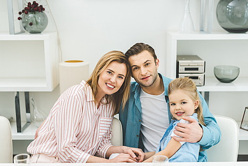 portrait of smiling parents and daughter  at home