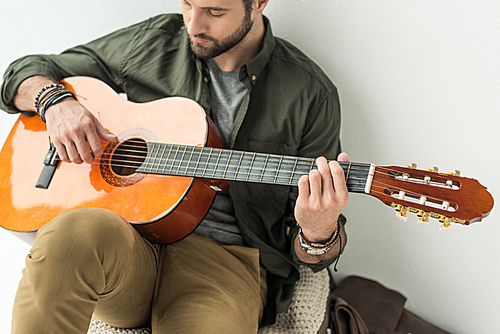 handsome man playing acoustic guitar