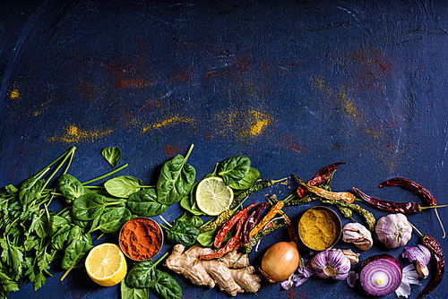 top view of tasty healthy herbs, vegetables and spices on blue