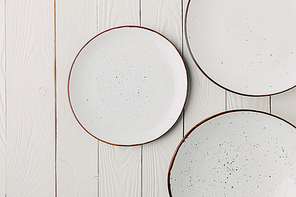 Ceramic glazed plates on white wooden background